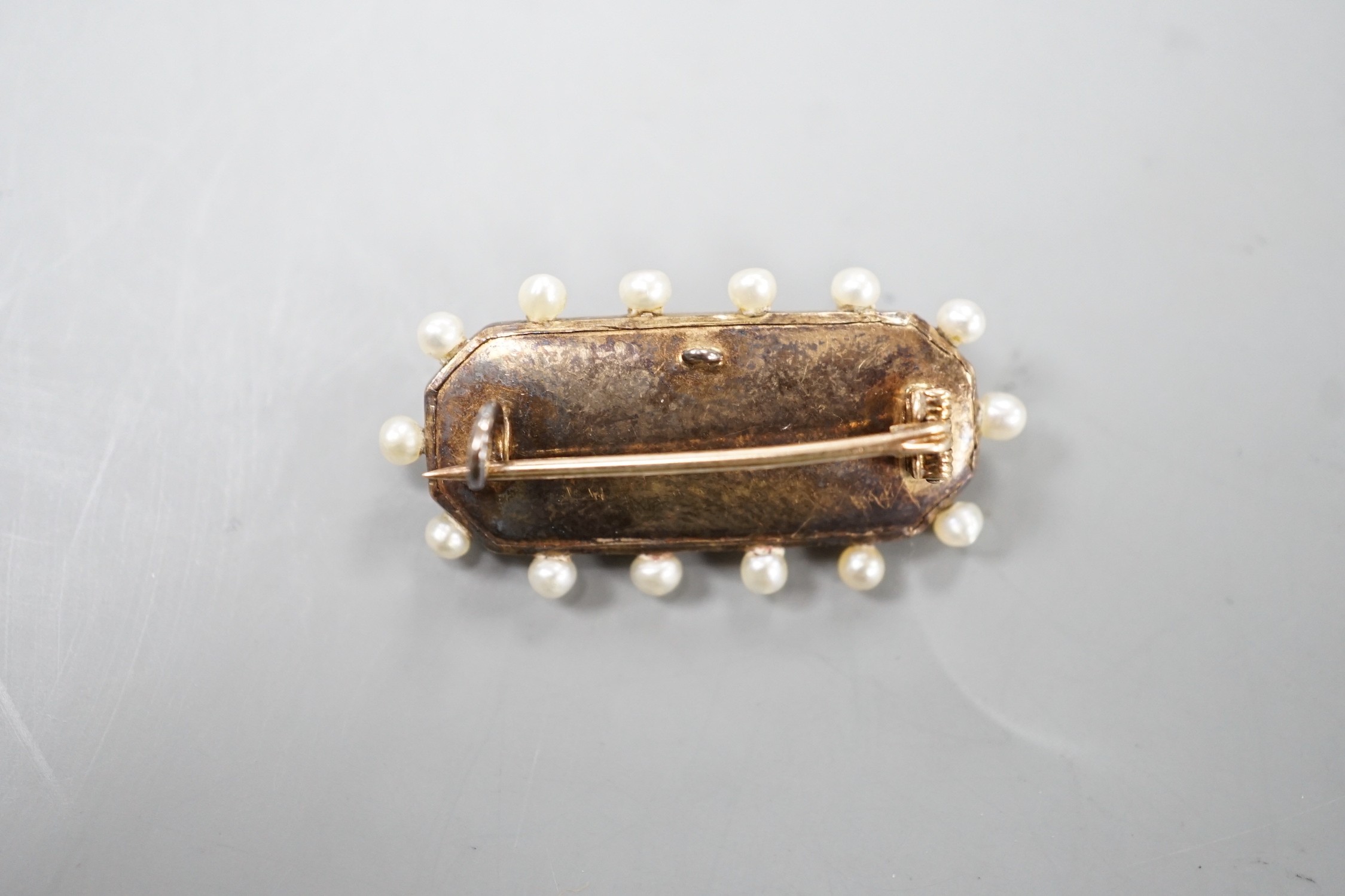 An Edwardian yellow metal, seed pearl, diamond and enamel set brooch, 31m, gross weight 5.4 grams.